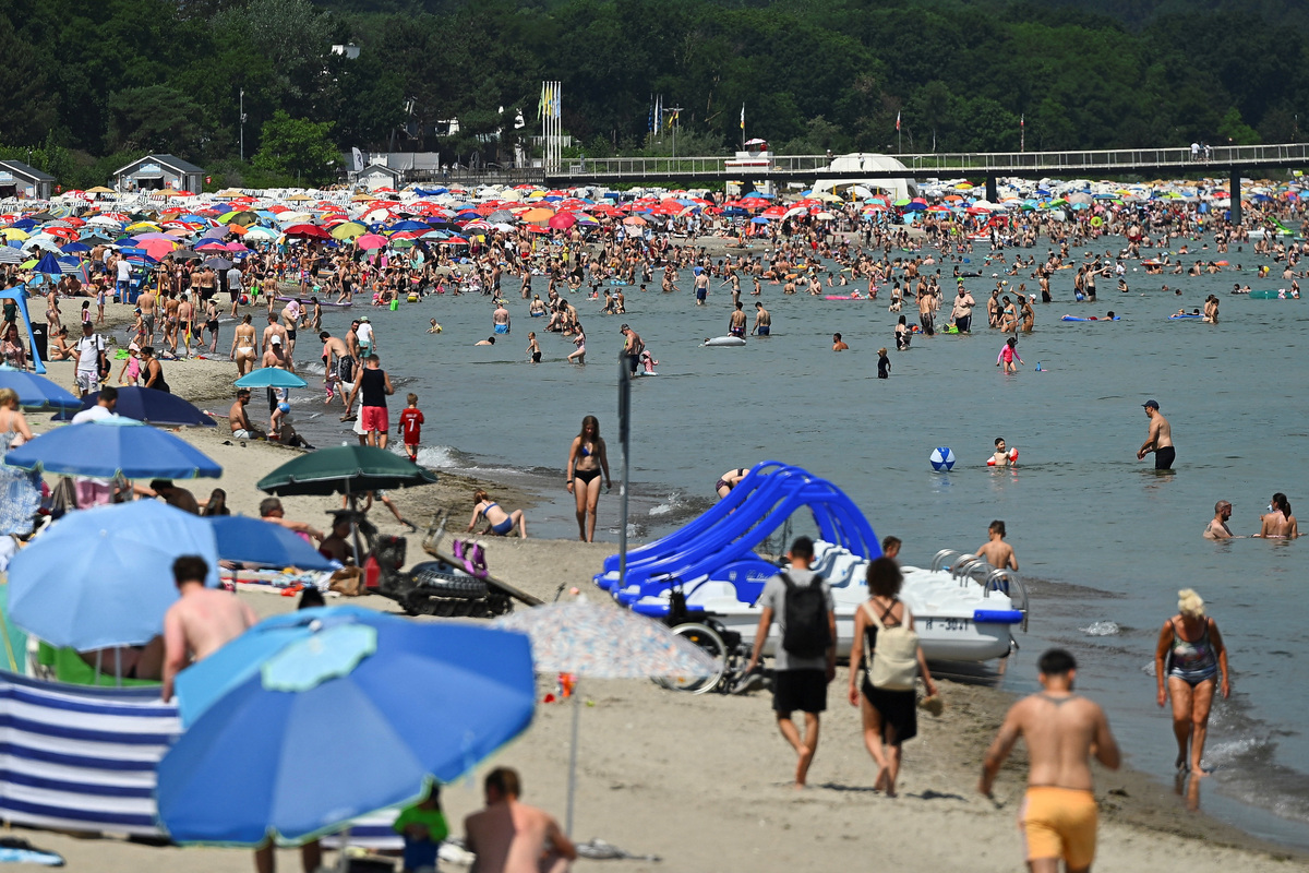 People enjoy at a beach as meteorologists forecast heat and record-breaking temperatures across the country, in Timmendorfer Strand, Germany, June 27, 2026. REUTERS/Jonas Walzberg