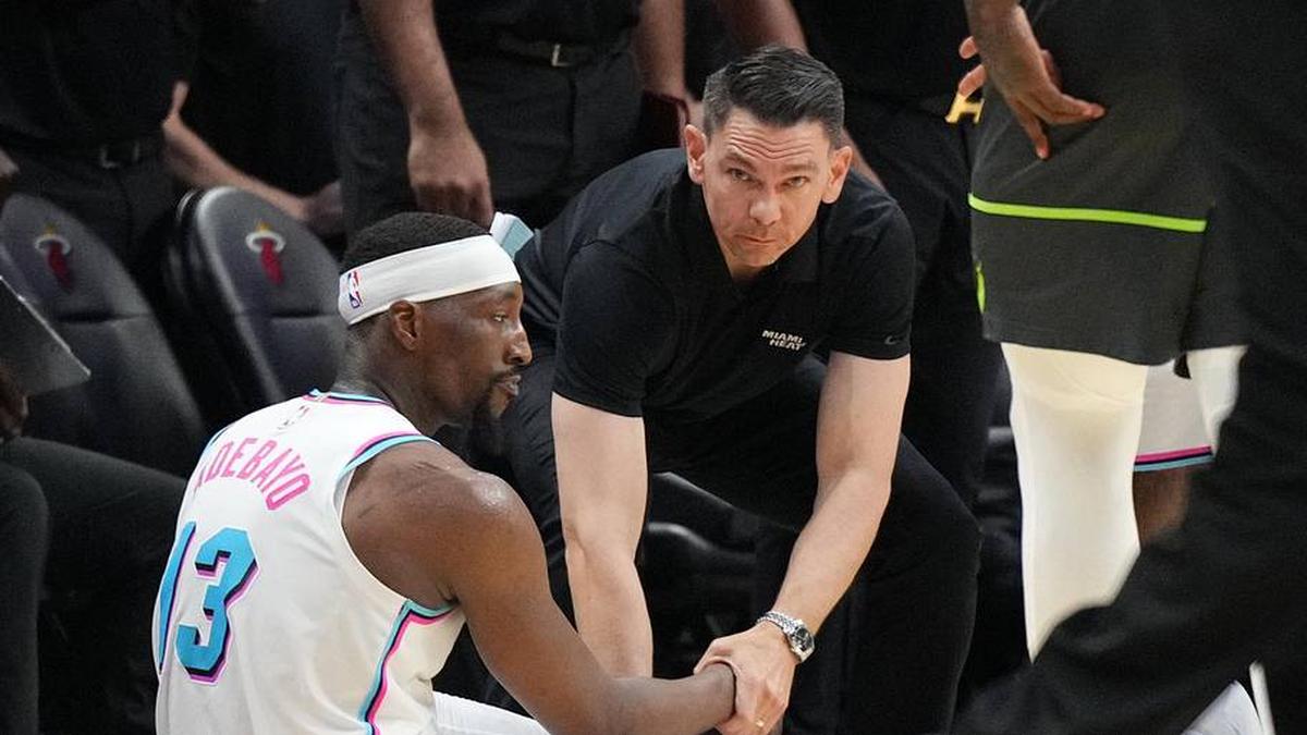  Mar 7, 2025; Miami, Florida, USA; Miami Heat center Bam Adebayo (13) takes a moment after missing a shot at the buzzer to lose the game against the Minnesota Timberwolves as assistant coach Chris Quinn comes to his aid at Kaseya Center. Mandatory Credit: Jim Rassol-Imagn Images | Jim Rassol-Imagn Images 