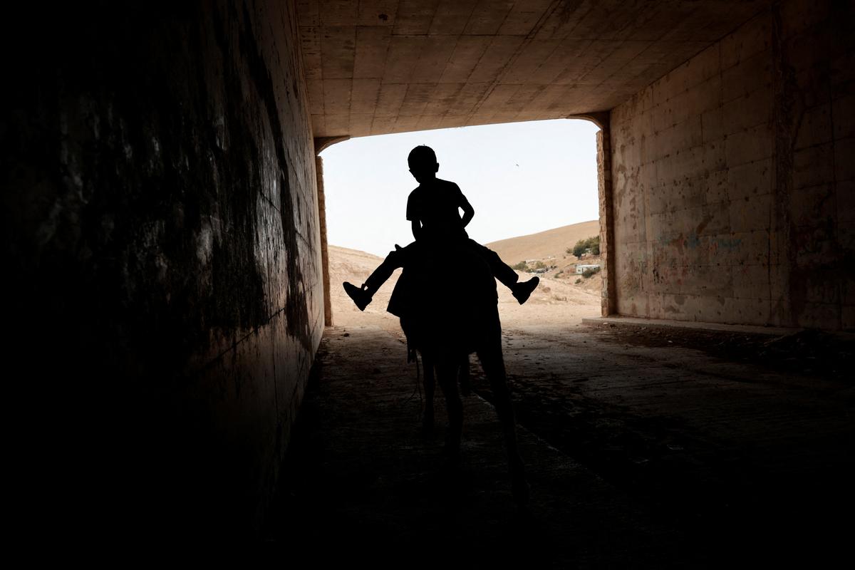 A Palestinian Bedouin child rides a donkey in al-Khan al-Ahmar near Jericho, in the Israeli-occupied West Bank, May 20, 2026. REUTERS/Mohammed Torokman