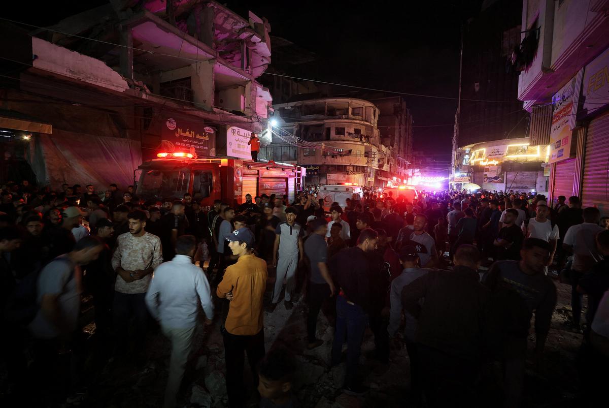 Palestinians gather in the street, to inspect the site of an Israeli airstrike on a residential building in Gaza City, May 26, 2026. REUTERS/Dawoud Abu Alkas