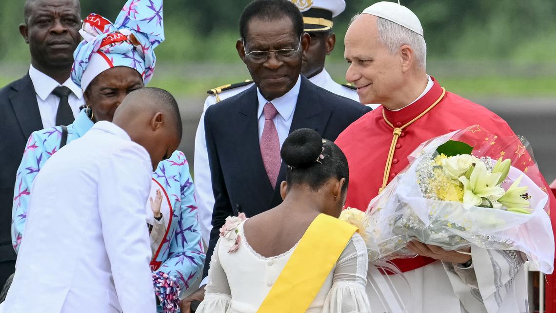 Pope Leo XIV (right) receives flowers from children as he is welcomed by Equatorial Guinea's President Teodoro Obiang Nguema Mbasogo (center) upon his arrival at the Malabo International Airport in Malabo on the ninth day of an 11-day apostolic journey to Africa, on April 21, 2026. (Alberto Pizzoli/AFP via Getty Images/TNS)