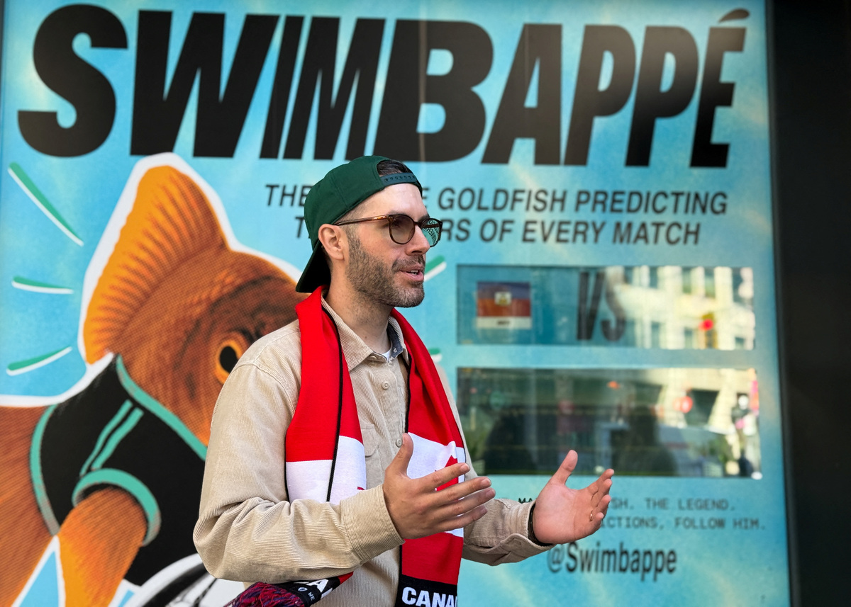 Tim Glenn, creative director at OneMethod, speaks in front of the window installation for Swimbappe, an oranda goldfish that has become a local attraction by making daily World Cup match predictions, outside an office building in downtown Toronto, Ontario, Canada, June 19, 2026. Glenn's creative studio designed the soccer-themed tank activation to allow the fish to make daily World Cup match predictions. Picture taken with a mobile phone. REUTERS/Kyaw Soe Oo