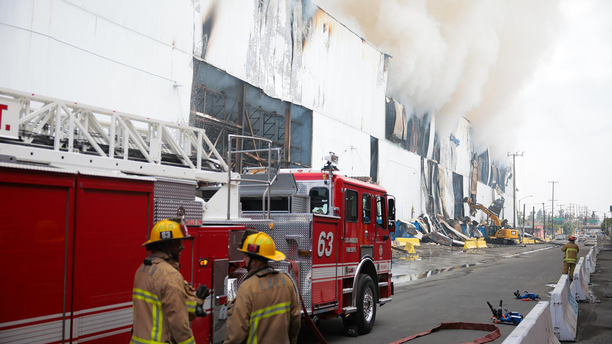 Smoke smolders from the Lineage cold storage facility as Los Angeles Fire Department firefighters battle a fire that flared back on Sunday, June 21, 2026, in Boyle Heights, California. (Kayla Bartkowski/Los Angeles Times/TNS)