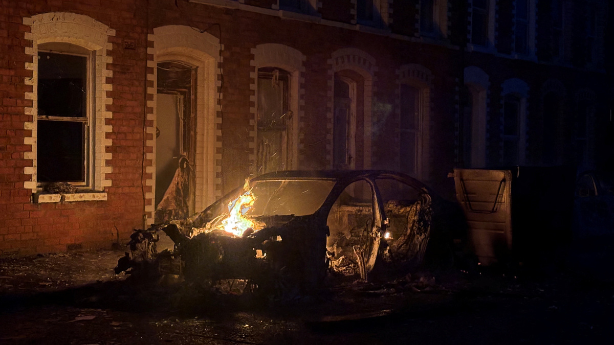 A car burns in east Belfast, during a protest after a knife attack on June 8 left a man seriously injured and prompted police to declare a critical incident, in Belfast, Northern Ireland, June 9, 2026. Picture taken wih a phone. REUTERS/Isabel Infantes