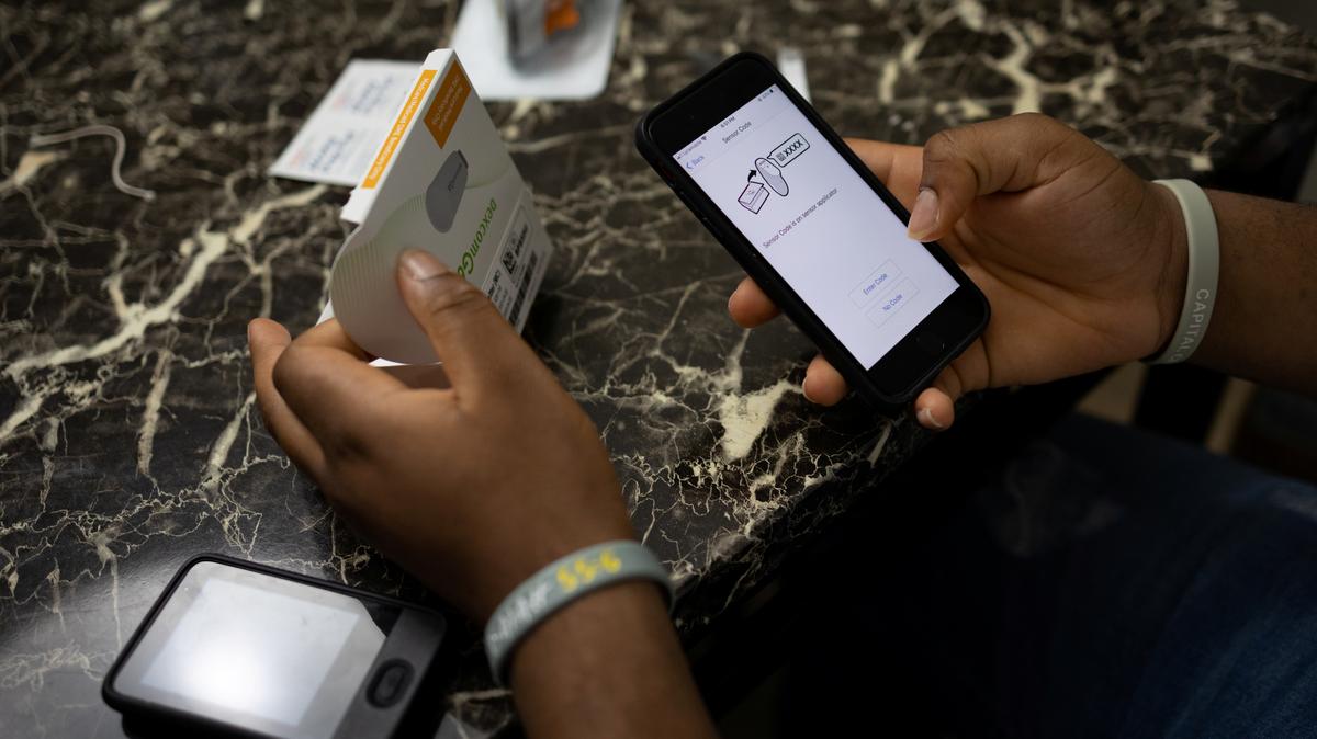 FILE PHOTO: A Type 2 diabetes patient registers his new Dexcom device, a continuous glucose monitoring system, at his home in Glenarden, Maryland, U.S., July 15, 2021. REUTERS/Hannah Beier/File Photo