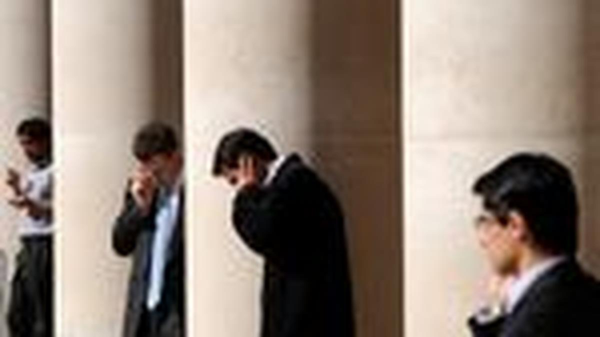 City workers make phone calls outside the London Stock Exchange in Paternoster Square in the City of London, Britain, October 1, 2008.  REUTERS/Toby Melville/File Photo