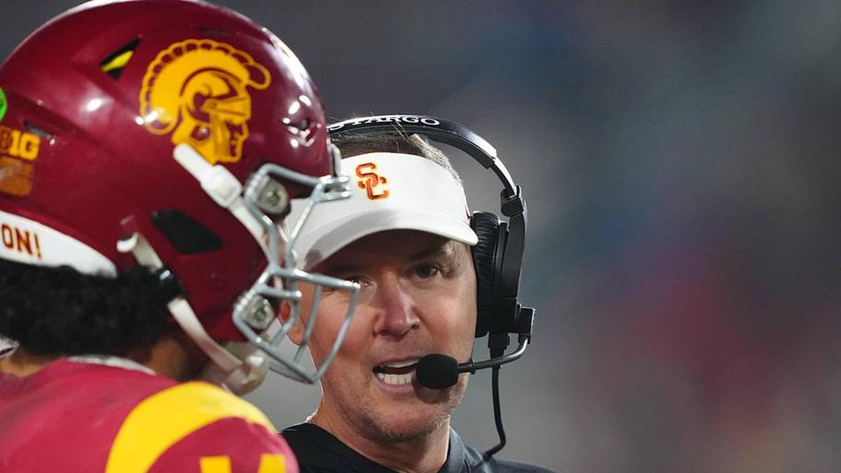  Nov 29, 2025; Los Angeles, California, USA; Southern California Trojans head coach Lincoln Riley (right) talks with quarterback Jayden Maiava (14) in the second half against the UCLA Bruins at United Airlines Field at Los Angeles Memorial Coliseum. Mandatory Credit: Kirby Lee-Imagn Images | Kirby Lee-Imagn Images 