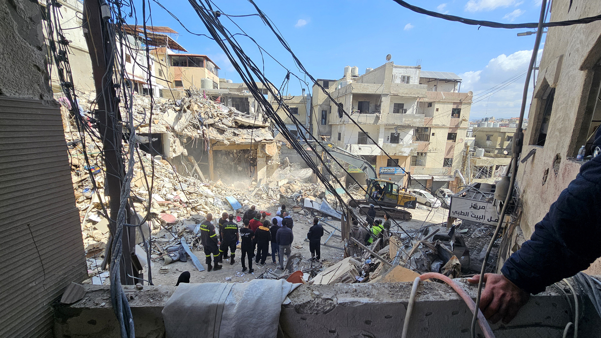 Workers clear rubble from the site of an Israeli airstrike the day before that targeted the Bir Hassan neighborhood in Beirut's southern suburbs on April 9, 2026.