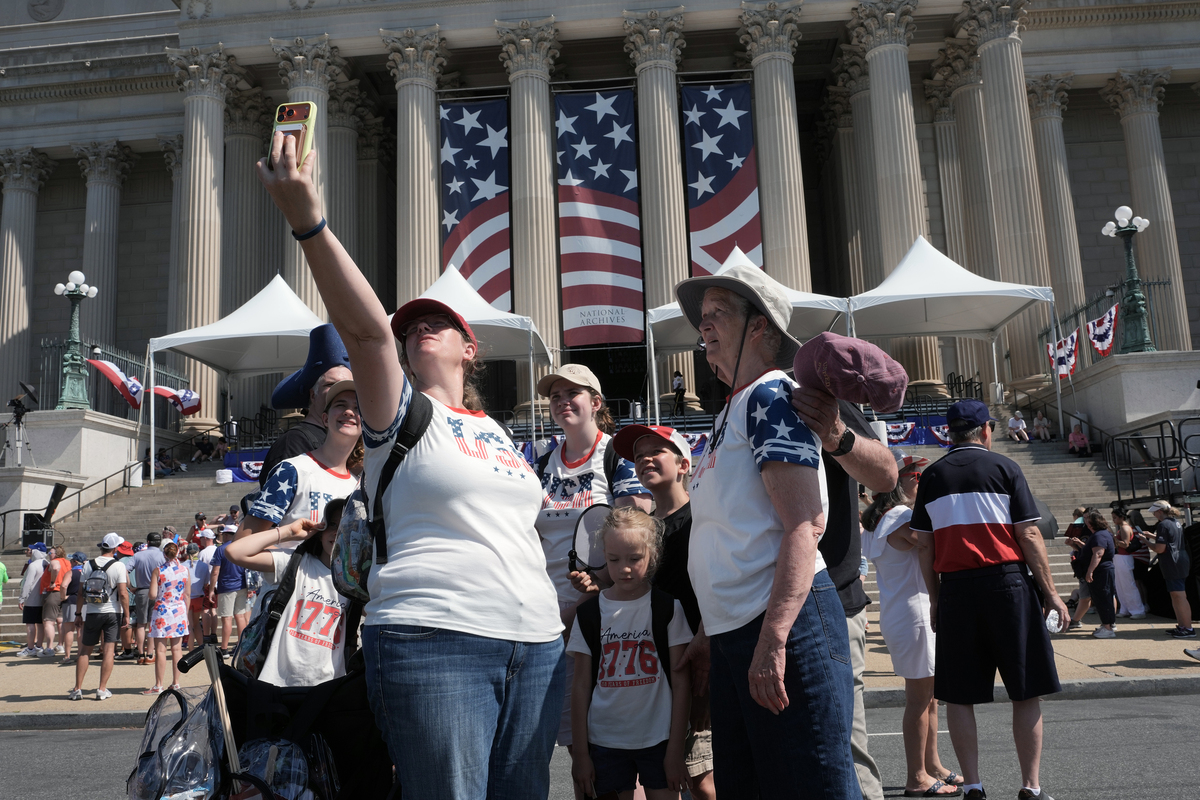 People stop outside the National Archives as they celebrate the 250th anniversary of the United States in Washington, July 4, 2026. America celebrates the 250th anniversary of its independence today, with people from one end of the country to the other marking the milestone with fireworks, parades and concerts. (Alex Kent/The New York Times)