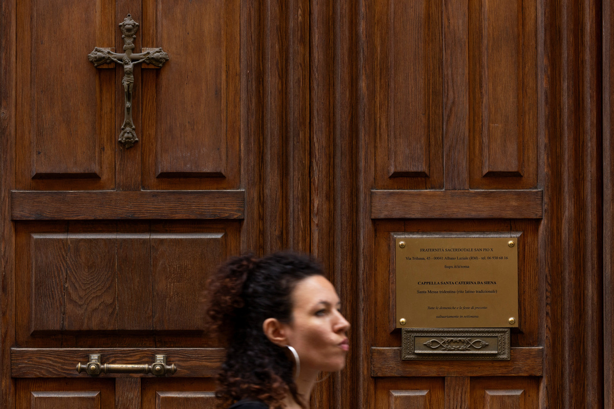 A woman walks past a sign at the entrance of Santa Caterina da Siena chapel where the Society of St Pius X celebrates Mass, on the day the Vatican declared the traditionalist Catholic group to be in schism following unauthorised bishop ordinations, in Rome, Italy, July, 2, 2026. REUTERS/Remo Casilli