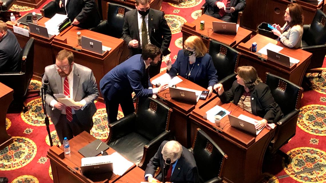 Members of the Missouri House -- some wearing masks, and other not -- huddle closely in conversations before the beginning of session on Wednesday, Feb. 3, 2021, in Jefferson City, Mo. The House chamber has no mask mandate and has not modified its seating during the coronavirus pandemic. The House canceled all work for a full week in January after a COVID-19 outbreak. (AP Photo/David A. Lieb)