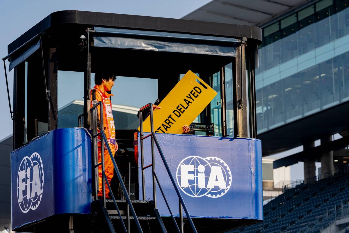  Marshals hold a 'Start Delayed' sign during the 2026 F1 Japanese Grand Prix. Photo by Marcel van Dorst/EYE4IMAGES/NurPhoto via Getty Images
