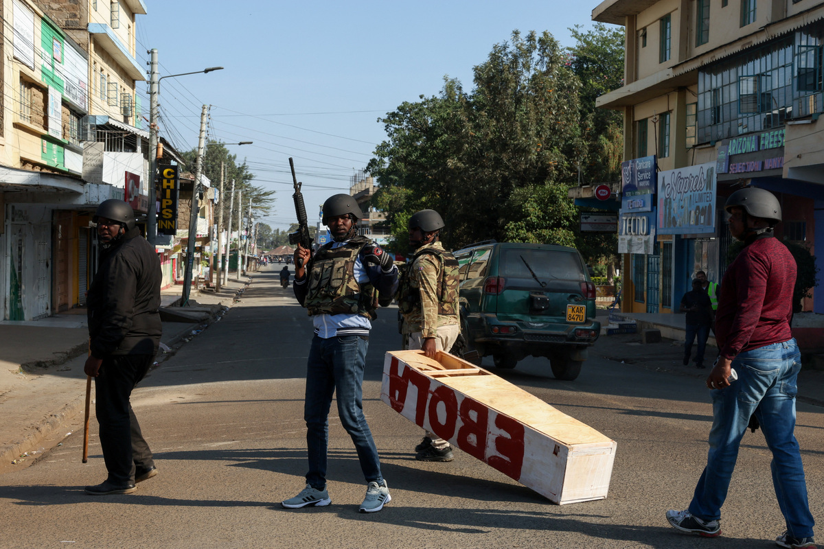 A police officer carries a mock coffin used as a prop by demonstrators, during a protest against a U.S.-backed Ebola quarantine plan to establish a 50-bed facility at a Kenyan air force base intended to host Americans exposed to Ebola, in Nanyuki town, Laikipia County, Kenya, June 9, 2026. REUTERS/Monicah Mwangi