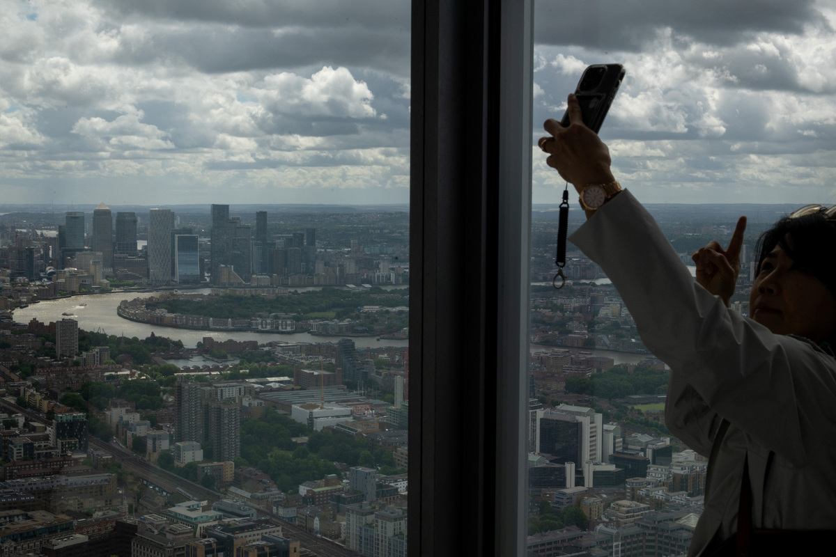 A woman takes a selfie at the Horizon 22 viewing platform with Canary Wharf seen in the background in London, Britain, June 9, 2026. REUTERS/Chris J. Ratcliffe