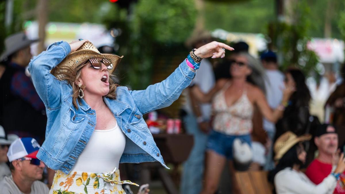 Indio, CA - April 25, 2026: A fan holds on to their hat during gusty winds and dances to Teddy Swims performance on the Mane Stage during the second day of the Stagecoach Country Music Festival at Empire Polo Club, in Indio, CA on Saturday, April 25, 2026. (Allen J. Schaben / Los Angeles Times)