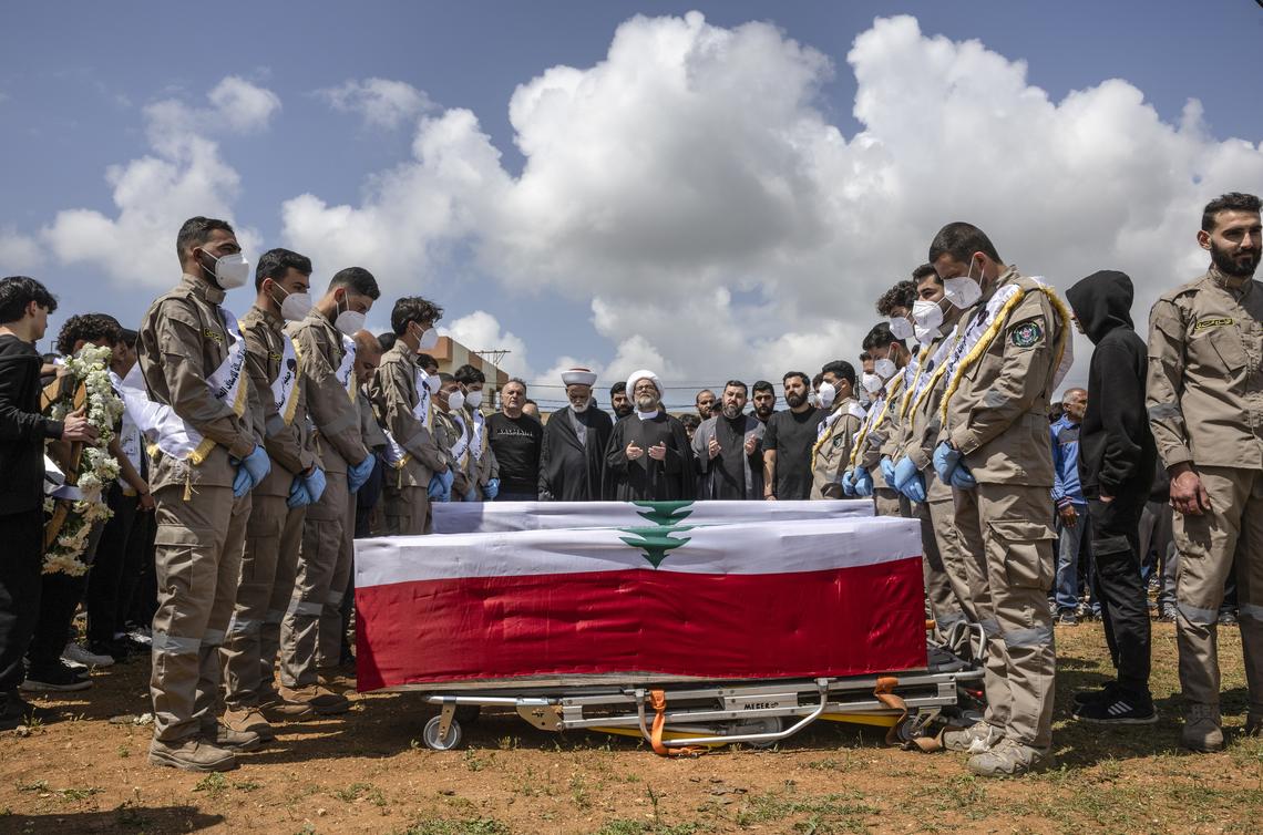 Mourners gather around coffins draped in the Lebanese flag during a mass funeral in the southern Lebanese village of Bazourieh, on Monday, April 20, 2026. Families gathered for the funeral of nine people -- both Hezbollah fighters and civilians -- who were killed in recent weeks.(David Guttenfelder/The New York Times)