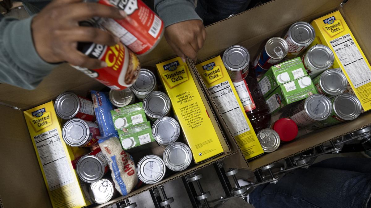 Volunteers pack boxes of shelf-stable food for a food bank.