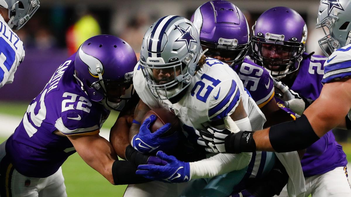 Dallas Cowboys running back Ezekiel Elliott (21) is tackled by Minnesota Vikings safety Harrison Smith (22) and defensive end Danielle Hunter (99) during the first half of an NFL football game, Sunday, Oct. 31, 2021, in Minneapolis. (AP Photo/Bruce Kluckhohn)