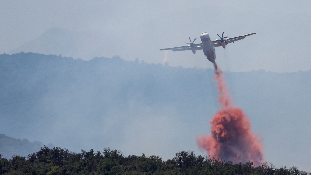 A firefighting plane drops fire retardant as it flies over a wildfire in Ille-sur-Tet near Bouleternere, in the Pyrenees-Orientales department, France July 6, 2026. REUTERS/Bruna Casas