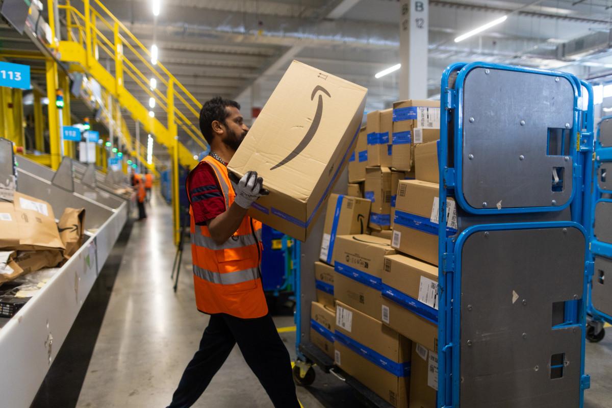 An employee places an item in to a distribution cage at the Amazon fulfillment center in Dartford, U.K..