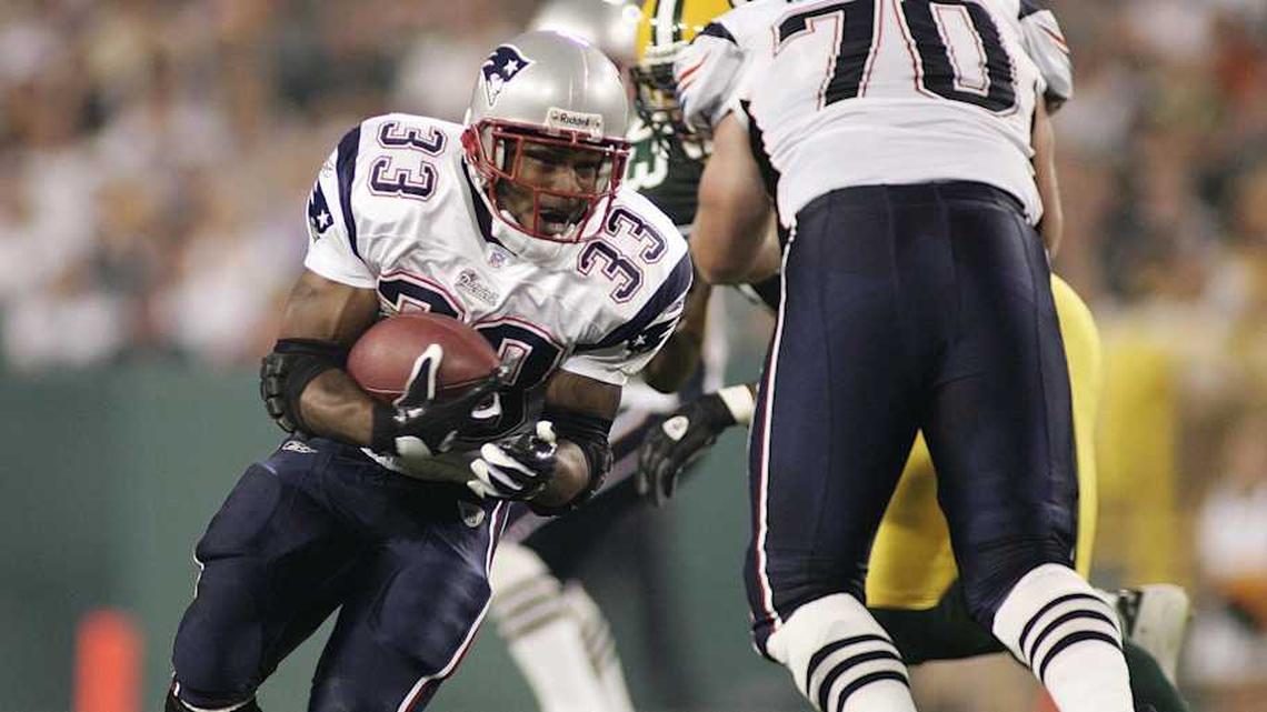  August 26, 2005; Green Bay, WI, USA; Kevin Faulk #33 of the New England Patriots carries the ball as Login Mankins #70 of the New England Patriots blocks during the second quarter as Mike Hawkins #27 Green Bay Packers defends at Lambeau Field. Mandatory Credit: Photo By Jeff Hanisch-Imagn Images Copyright (c) 2005 Jeff Hanisch | Jeff Hanisch-Imagn Images 