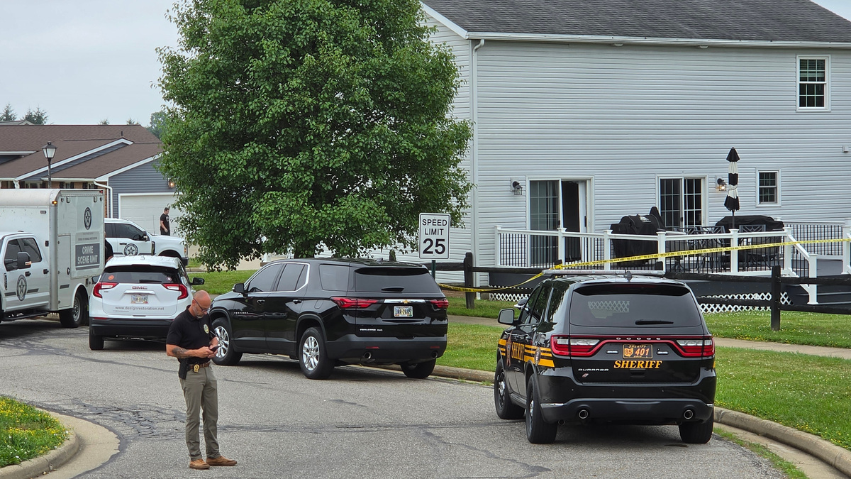 A law enforcement officer works Monday, July 6, outside the Rittman home where four people, including a police officer, were killed in a shooting on Chippewa Trail the night of July 5.