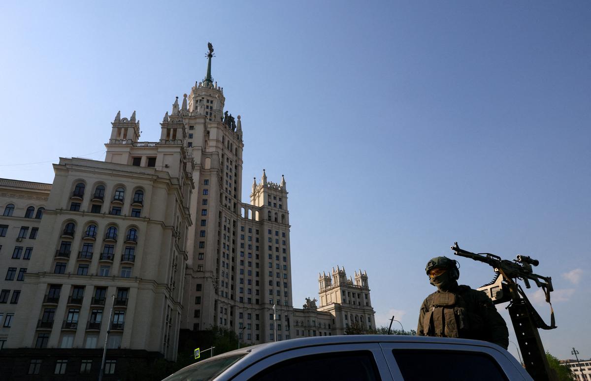 A security guard stands atop a pickup truck armed with a machine gun while patrolling an area in central Moscow, Russia, May 7, 2026. REUTERS/Anastasia Barashkova