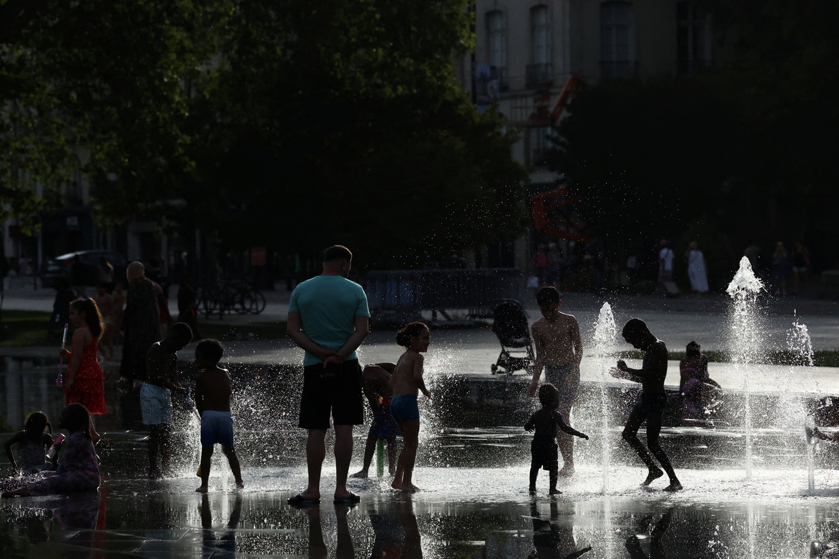 People cool off in the Miroir d'eau (Mirror of Water) in Nantes during a heatwave affecting a large part of France, June 24, 2026. REUTERS/Stephane Mahe