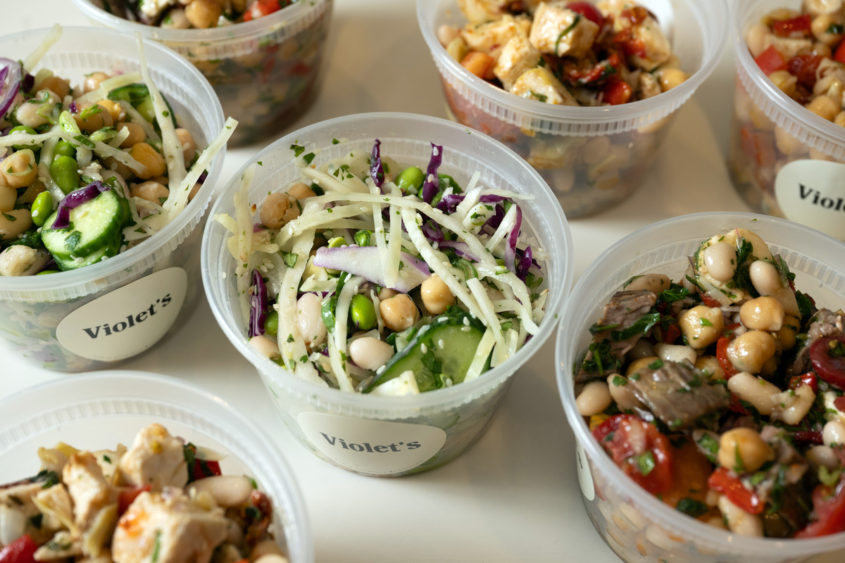 Dense bean salads with grilled steak and chimichurri; miso and edamame; and sun-dried tomato are among the offerings at Violet Wechel's event at Pop Up Grocer in Manhattan on Sunday, May 31, 2026. Witchel, a content creator based in San Francisco, has built a fan base on her bean-packed salads. (Liz Clayman/The New York Times)