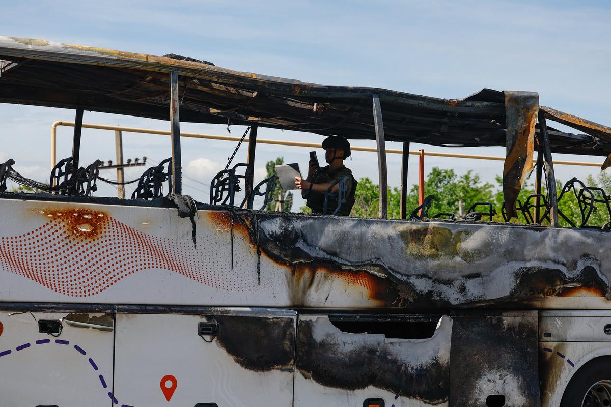 An investigator works on a site of a Ukrainian drone attack on a bus, according to local authorities in the course of the Russia-Ukraine military conflict, in the settlement of Yenakiievo in the Donetsk region, a Russian-controlled part of Ukraine, June 3, 2026.  REUTERS/Alexander Ermochenko