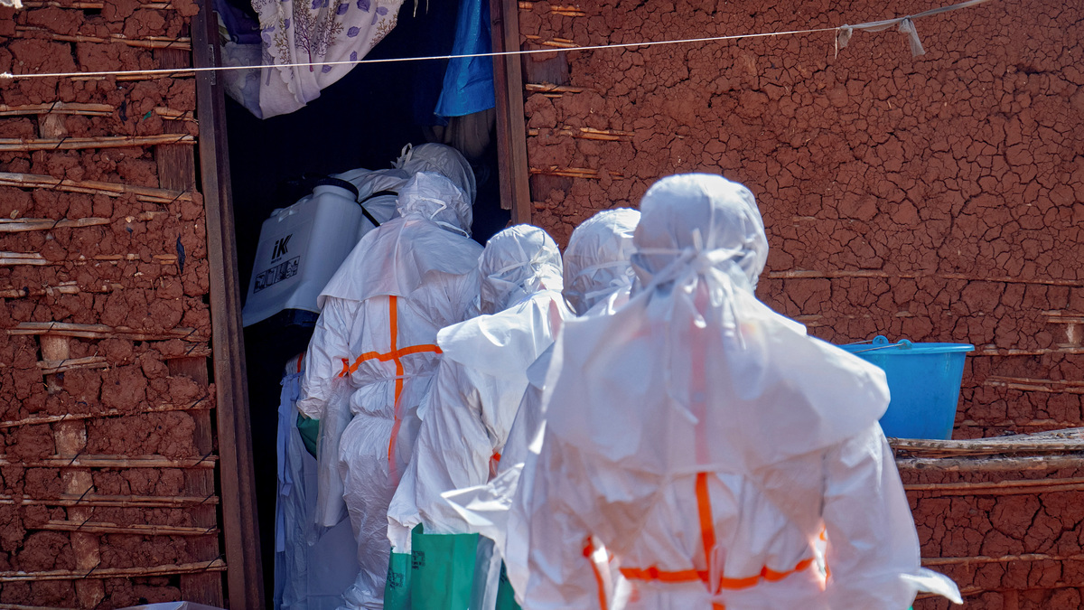 Red Cross workers wearing personal protective equipment (PPE) disinfect the house of an unidentified man who died of Ebola, before retrieving his body, as aid agencies intensify efforts to contain a new Ebola outbreak involving the Bundibugyo strain, in Quartier Shuni 1, a residential sector in Mongbwalu, Djugu Territory of Ituri province, Democratic Republic of the Congo, May 24, 2026. REUTERS/Gradel Muyisa Mumbere