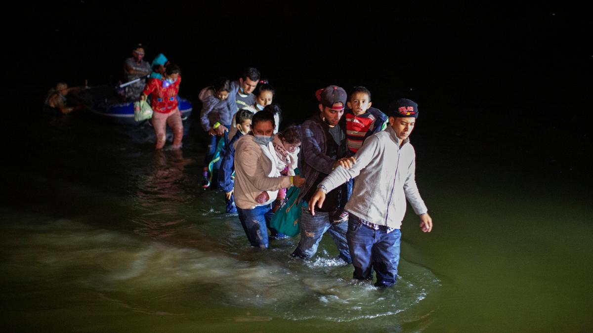 Familias inmigrantes, la mayoría de América Central, cruzan un río después que “coyotes” en botes inflables los ayudaron a pasar la frontera de Estados Unidos, cerca de la ciudad de Roma, Texas, el 24 de marzo de 2021.