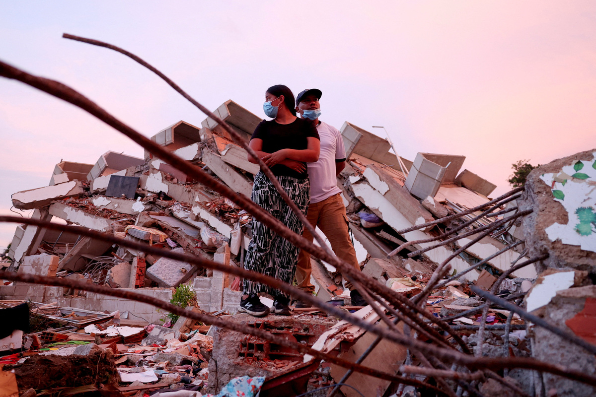 Yohancy Gil, 24 and her husband Sergio Guanipa, 30, stand on rubble as they wait for news from rescue teams looking for their children under the rubble at the site of a collapsed building in the aftermath of earthquakes, in La Guaira, Venezuela, June 30, 2026. REUTERS/Ricardo Arduengo  REFILE - QUALITY REPEAT     TPX IMAGES OF THE DAY