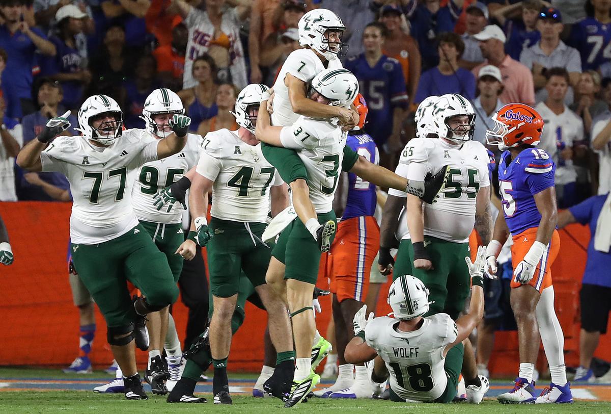 USF kicker Nico Grammatica (7) is hoisted by teammates after kicking the winnng field goal as time ran out during the USF at UF college football game at Ben Hill Griffin Stadium in Gainesville on Saturday, September 6, 2025. USF won the game 18-16. (Stephen M. Dowell/Orlando Sentinel)