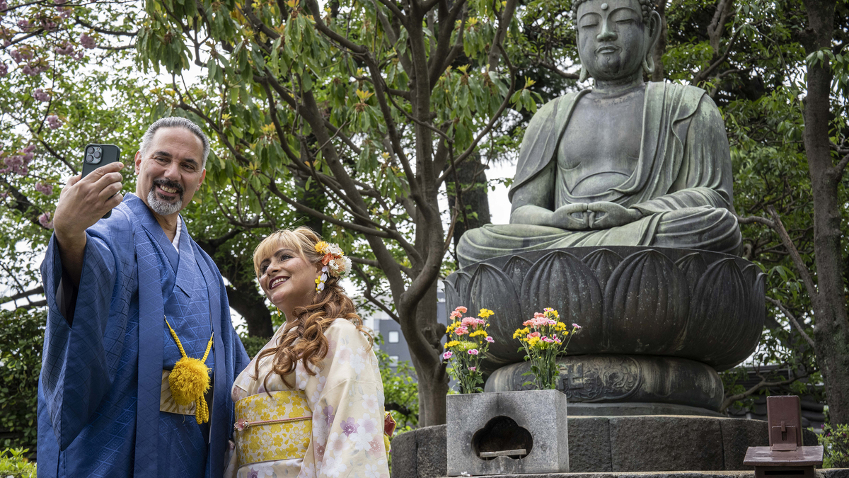 Foreign tourists take selfies with a statue of Buddha in the Asakusa area of Tokyo on April 15, 2026. A record number of tourists visited Japan in March, the official tourism board said on April 15, despite a sharp drop in Chinese visitors after the relationship between Beijing and Tokyo have soured. (Yuichi Yamazaki/AFP/Getty Images/TNS)