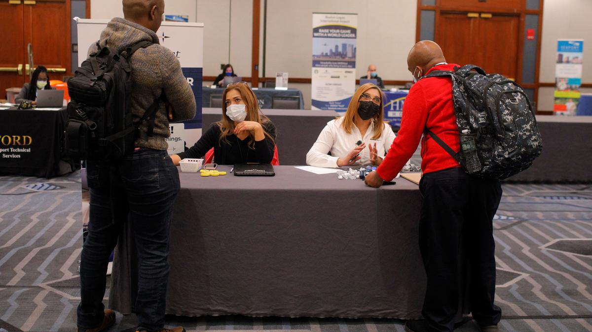 Job seekers talk to representatives from Prime Flight at a job fair at Logan International Airport in Boston, Massachusetts, U.S., December 7, 2021.   REUTERS/Brian Snyder