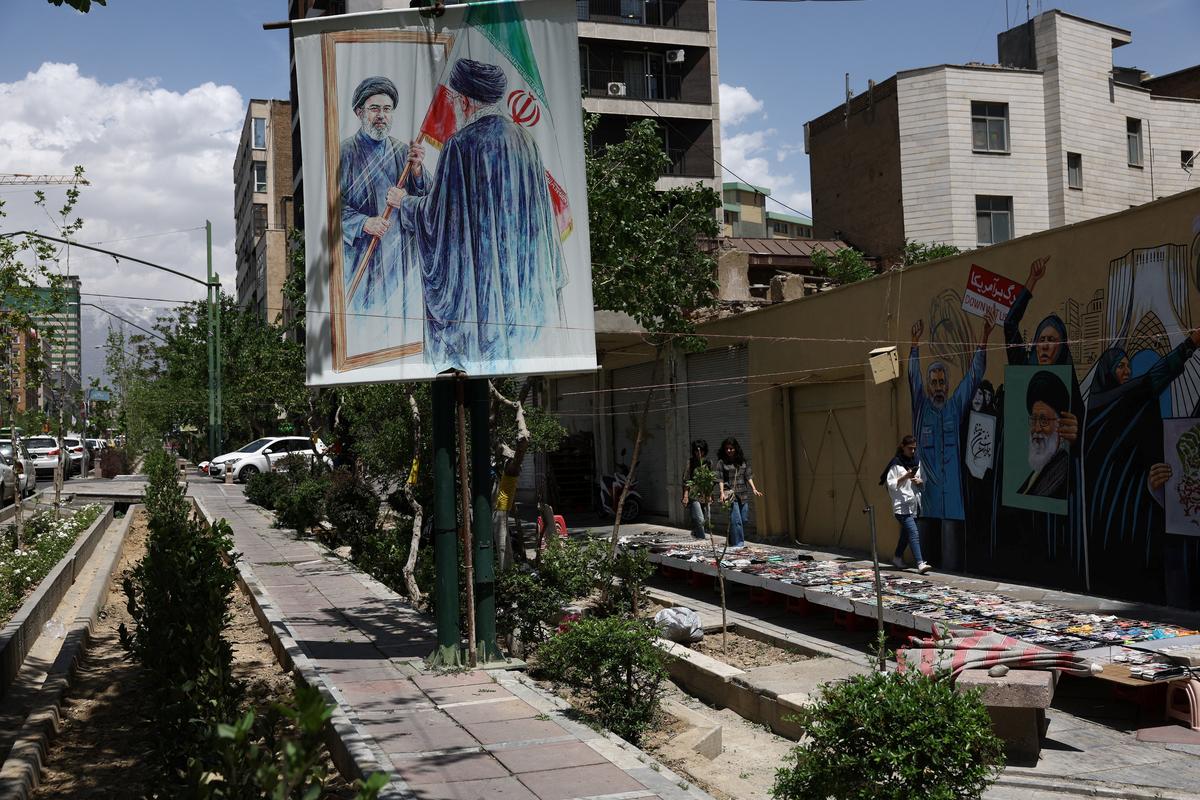 People walk on a street near a mural featuring an image of the late Supreme Leader of Iran, Ayatollah Ali Khamenei, in Tehran, Iran, May 6, 2026. Majid Asgaripour/WANA (West Asia News Agency) via REUTERS