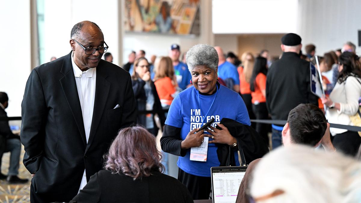 From left, Joseph Grandberry, a UAW representative at Milford Proving Ground, from left, waits while staff tries to clear up a technical issue so that he can vote next to Beverly Kindle-Walker of Detroit, right, who just received her activation code so that she can vote during the Michigan Democratic Party nominating convention at Huntington Place on April 19, 2026, in Detroit. Grandberry was never able to vote while Kindle-Walker spent more than two hours waiting in line and then more time waiting for the issue to be cleared up but eventually was able to vote. She says, "It was worth the wait to make sure that my vote was counted." (Robin Buckson/The Detroit News/TNS)