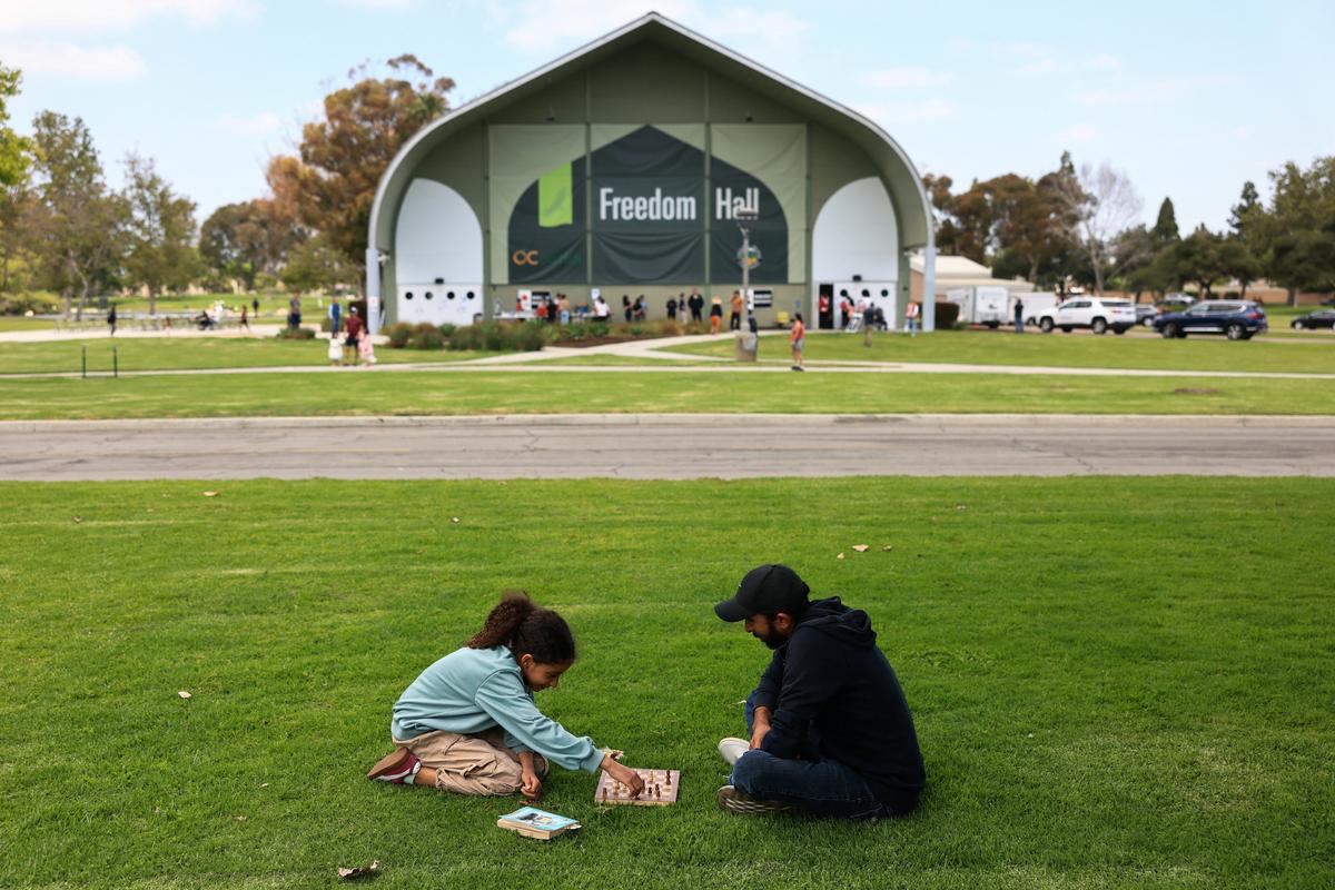 A man and a girl play chess outside a shelter prepared for evacuees from an area affected by a chemical incident involving a leaking tank of methyl methacrylate, a flammable liquid used in the aerospace industry, in Fountain Valley, California, U.S., May 23, 2026. The incident occurred in Garden Grove. REUTERS/David Swanson