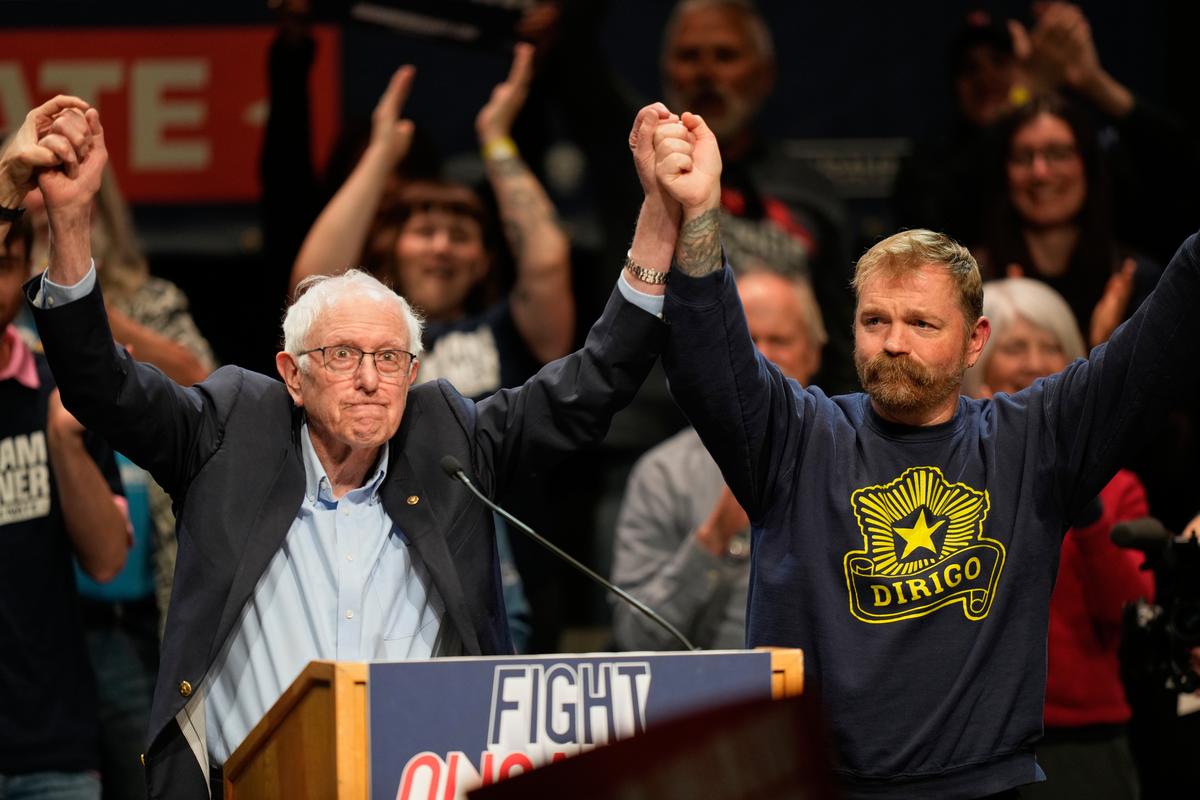  Senator Bernie Sanders (L) and Graham Platner join hands at an event in Orono, Maine, on May 24, 2026. 