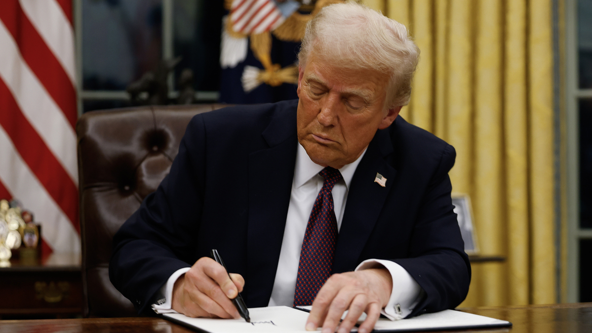President Donald Trump signs executive orders in the Oval Office at the White House last January.
