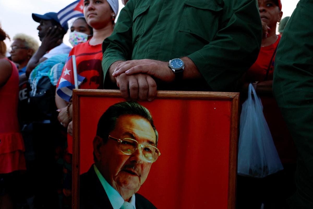 A person holds a picture of former Cuban president Raul Castro, as people gather ahead of a pro-government rally called by Cuban authorities to protest U.S. policies toward the island, including the indictment of Castro, in Havana, Cuba, May 22, 2026. REUTERS/Norlys Perez