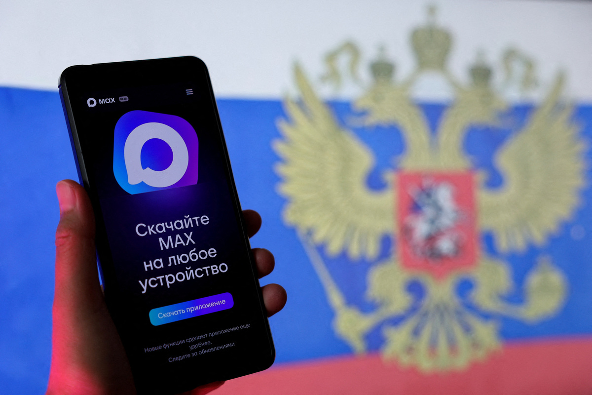 The Russian messaging app MAX is displayed on a smartphone next to a screen showing the state flag of Russia in this illustration taken September 4, 2025. REUTERS/Ramil Sitdikov/Illustration