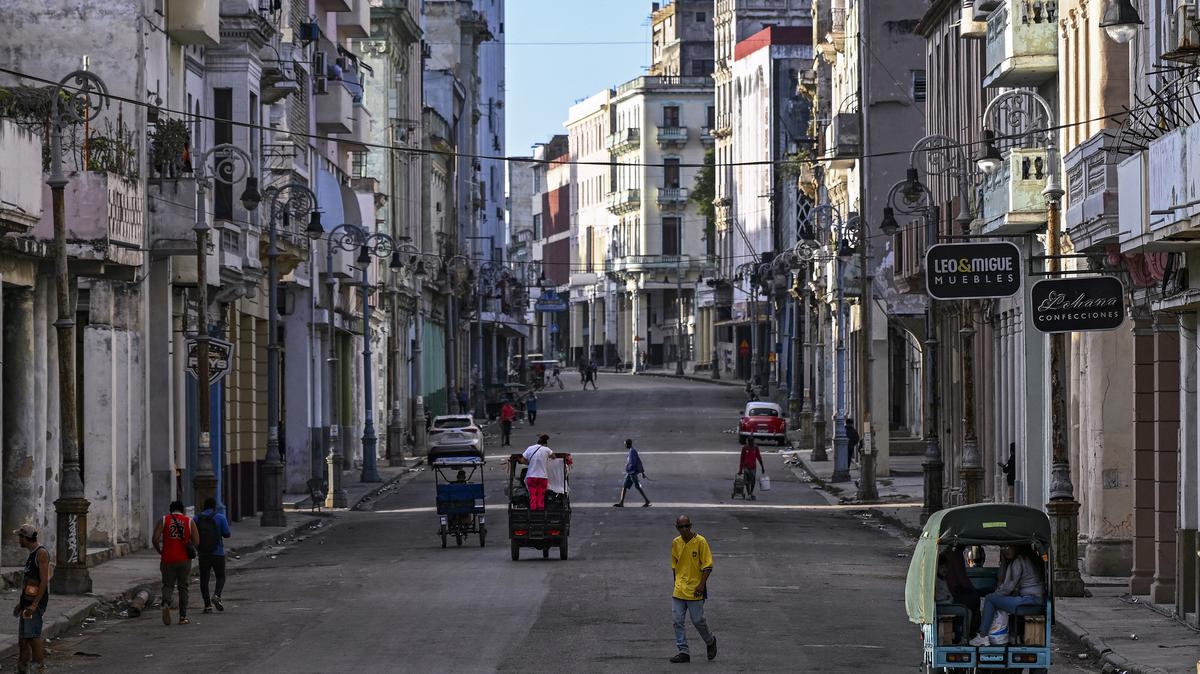 People walk and ride on a street without power during a nationwide blackout in Havana, Cuba, on March 22, 2026.