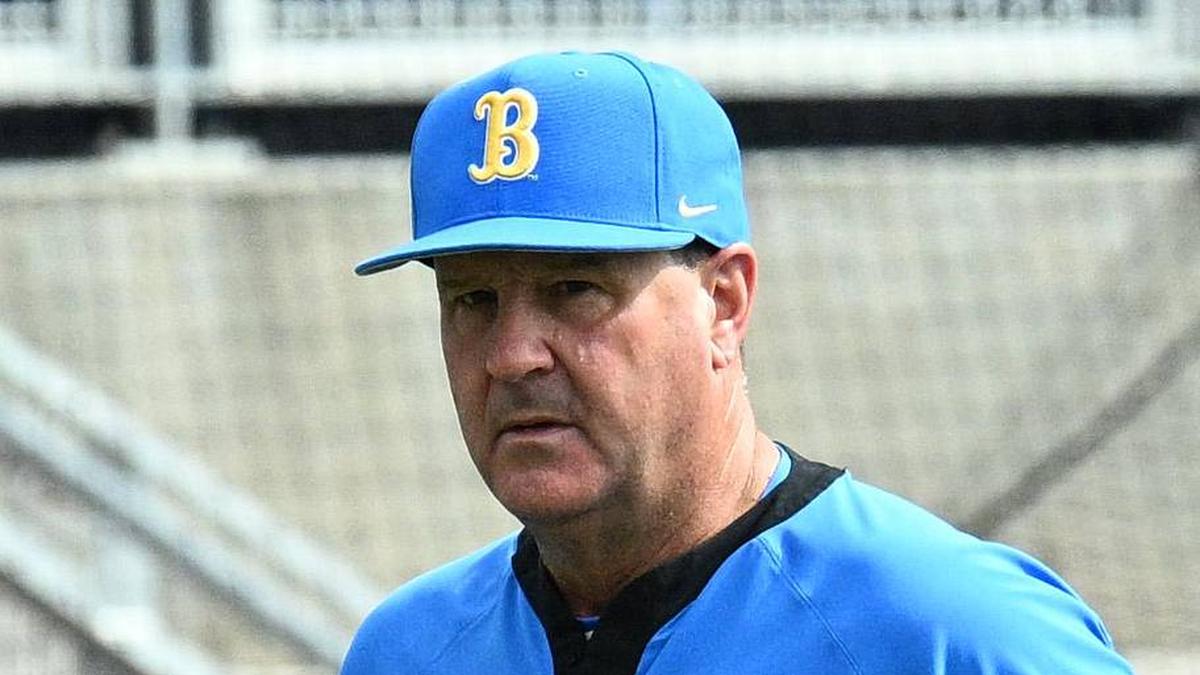  Jun 17, 2025; Omaha, Neb, USA; UCLA Bruins head coach John Savage (22) walks to the dugout before the restart of the game against the LSU Tigers at Charles Schwab Field. Mandatory Credit: Steven Branscombe-Imagn Images | Steven Branscombe-Imagn Images 