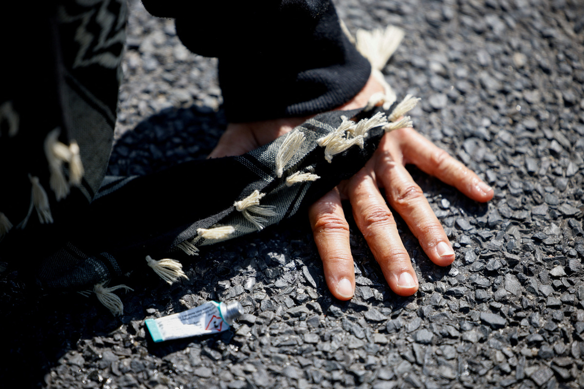 An activist's hand is glued to the tarmac as they block a road to the venue during protest on the opening day of the International Aerospace Exhibition ILA at Schoenefeld Airport in Berlin, Germany, June 10, 2026. REUTERS/Axel Schmidt