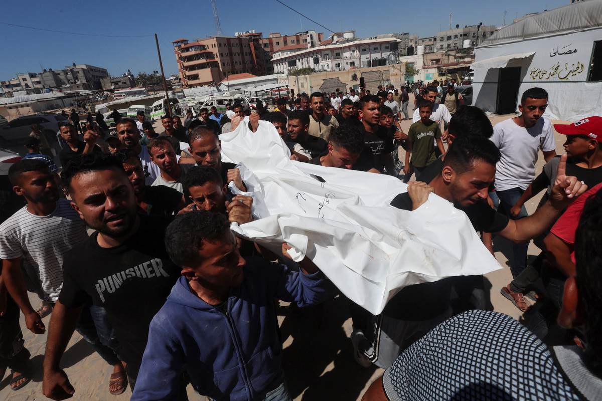 Palestinians carry a body outside the Nasser hospital following an Israeli strike on a police station, in Khan Younis in the southern Gaza Strip, June 7, 2026, REUTERS/Ramadan Abed