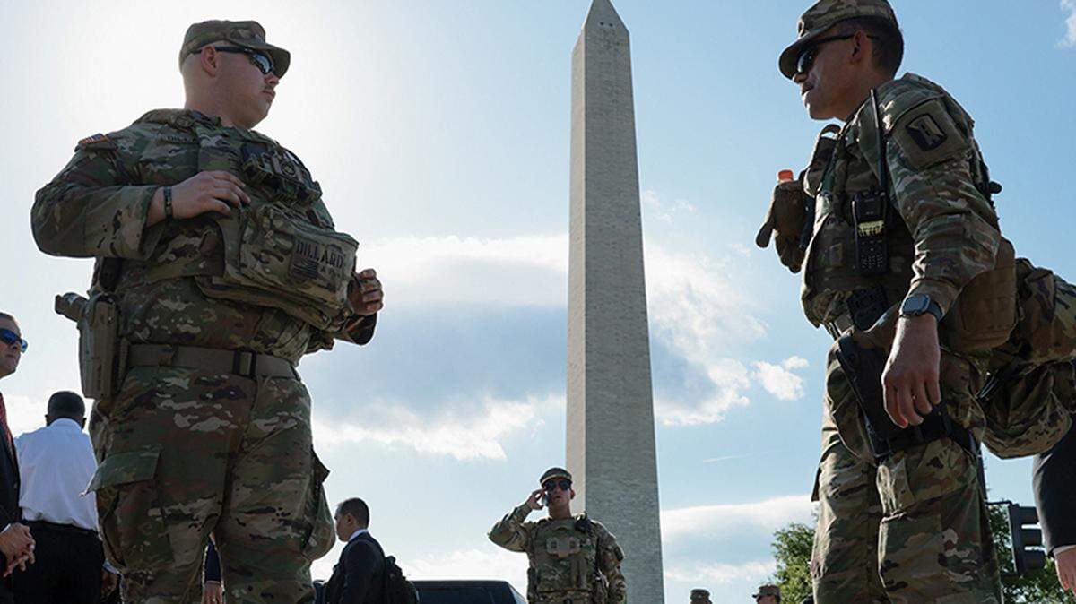 Law enforcement officers stand watch behind a cordoned-off area after a Secret Service agent shot and wounded a gunman at the Washington Monument in Washington, D.C., on Monday.