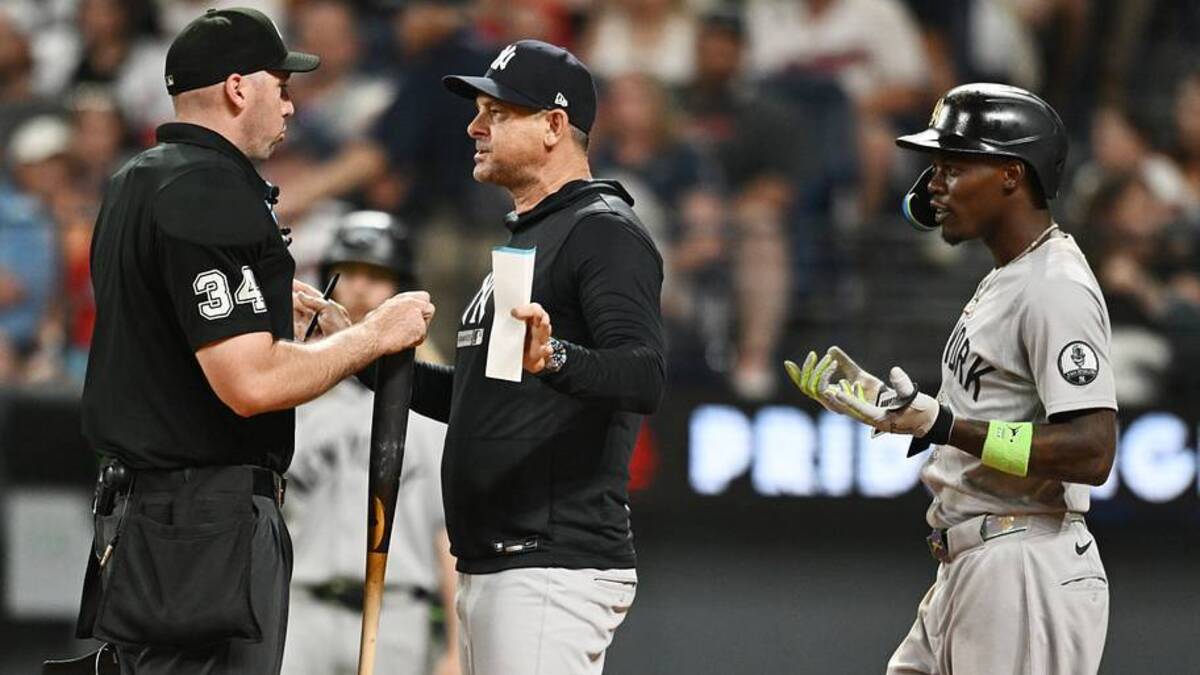  New York Yankees manager Aaron Boone (17) talks with umpire Nate Tomlinson (34) as second baseman Jazz Chisholm Jr. (13) looks on during the tenth inning against the Cleveland Guardians at Progressive Field. | IMAGN IMAGES via Reuters Connect 