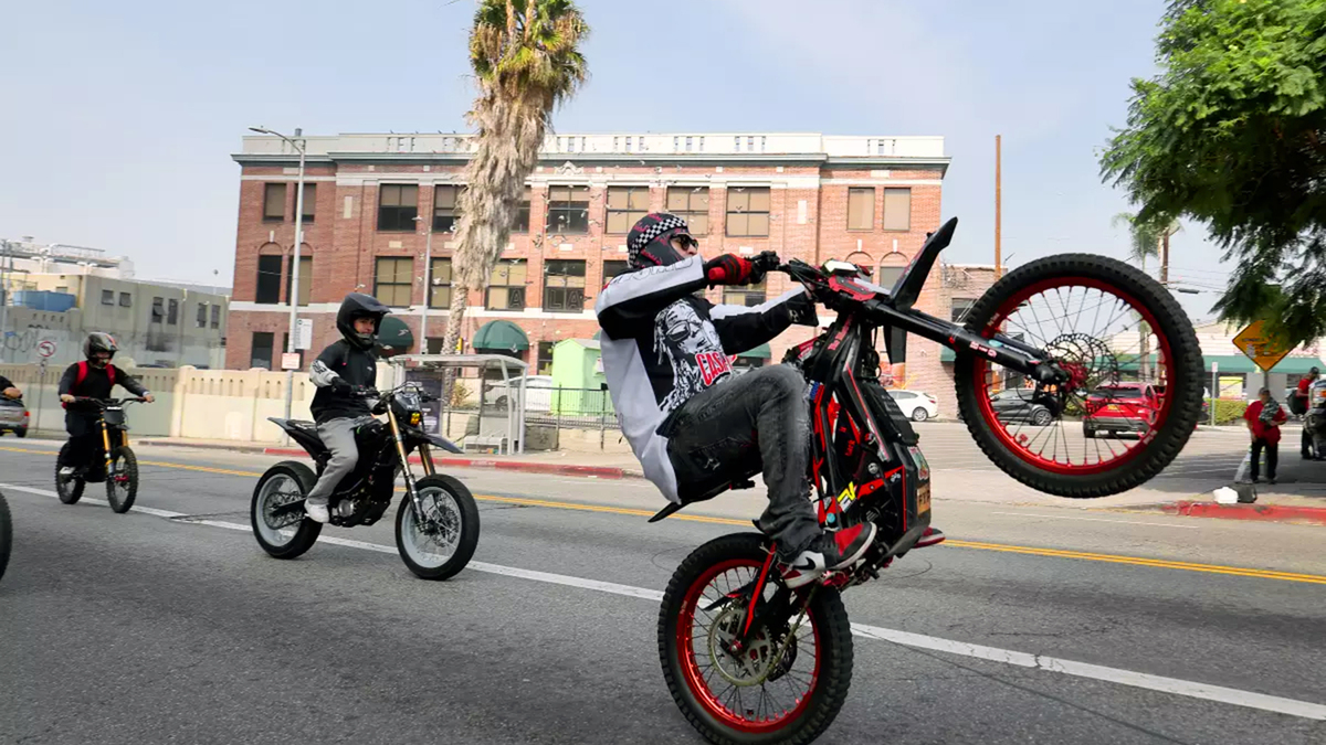 A group rides powerful e-bikes through downtown L.A. in October 2025, weaving in and out of traffic and doing tricks. (Allen J. Schaben/Los Angeles Times/TNS)